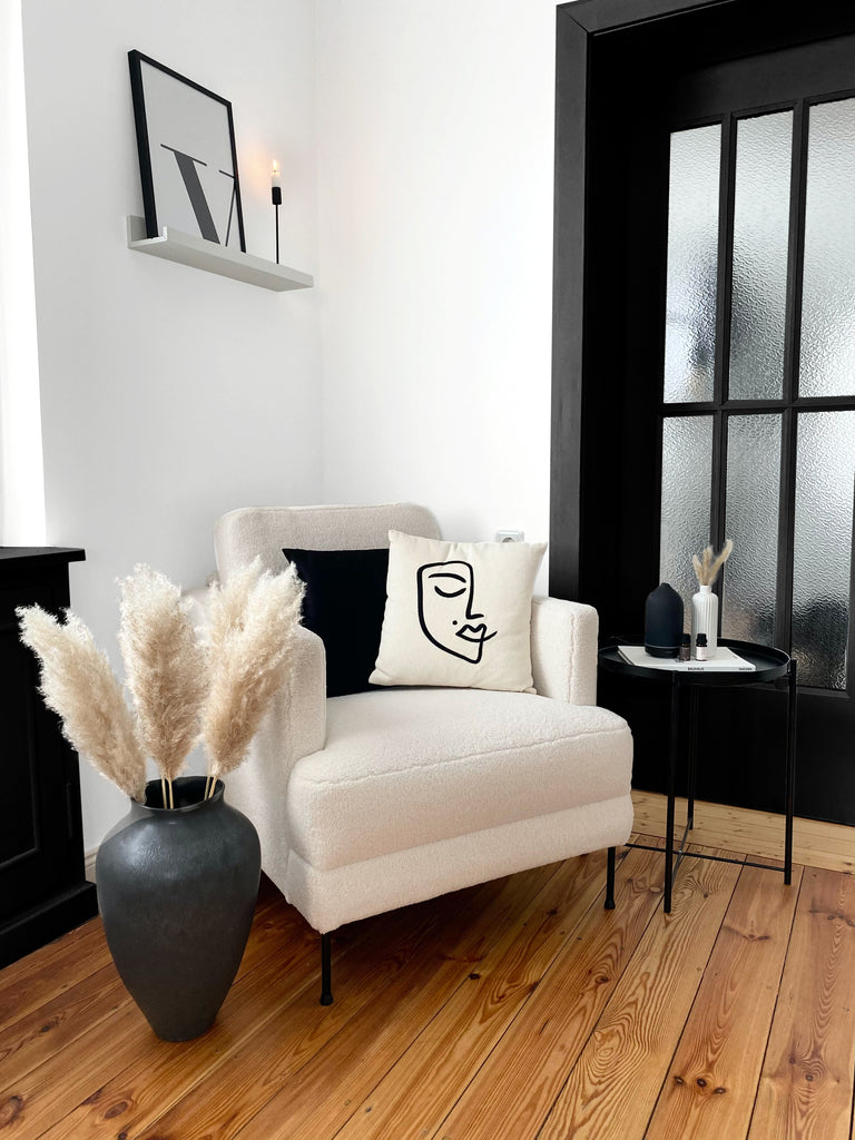 Living room corner with neutral furniture, neutral walls and wooden door painted black