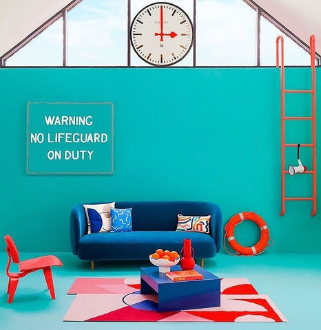 lido inspired living room in Wes Anderson style with aqua coloured walls, teal sofa and nautical home decor accessories