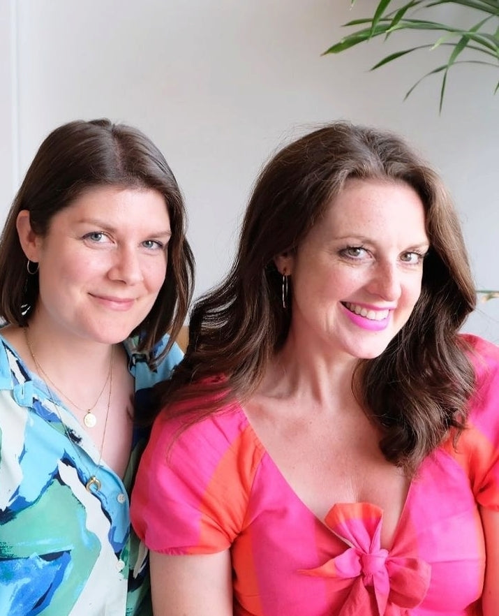 Portrait photo of two women with mid-length hair, dressed in turquoise and blue shirt and pink and orange dress.