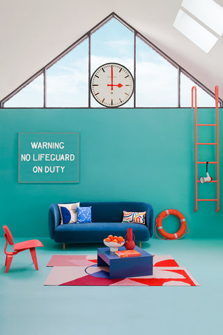 A bright teal room with sofa with a nautical feel