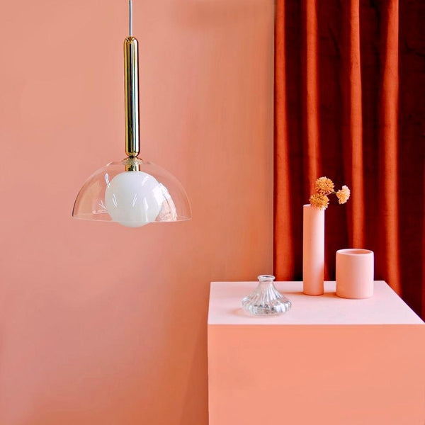 Peach-painted cube with peach-coloured vases, a burnt orange curtain and a transparent ceiling light photographed on a peach-painted wall