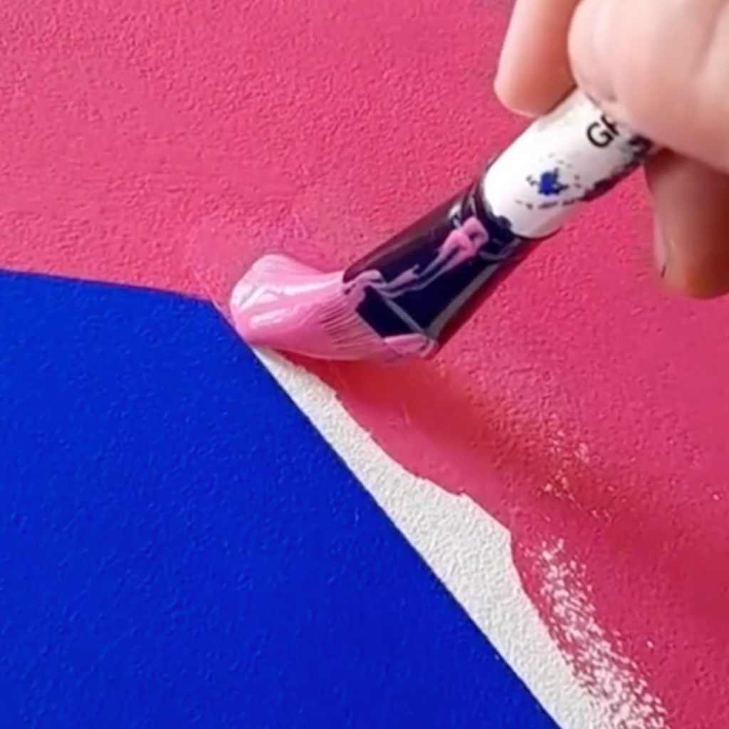 Photo of paint brush painting a flat surface in YesColours Passionate Pink and Electric Blue paint