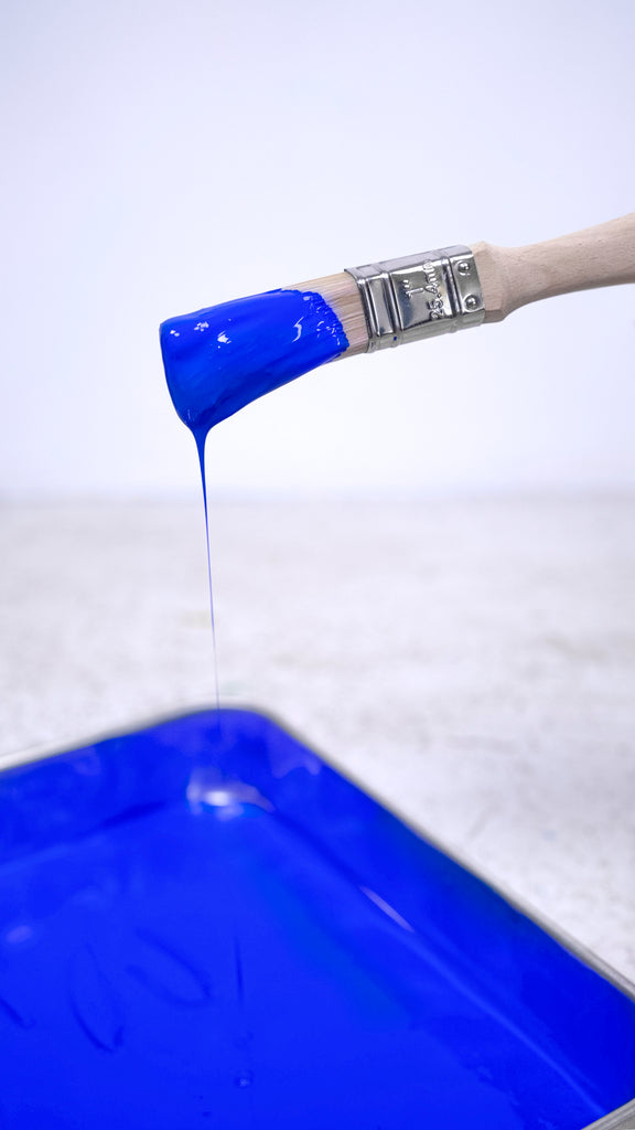 Photo of paint tray filled with YesColours Electric Blue paint and a paint brush dipped in blue paint
