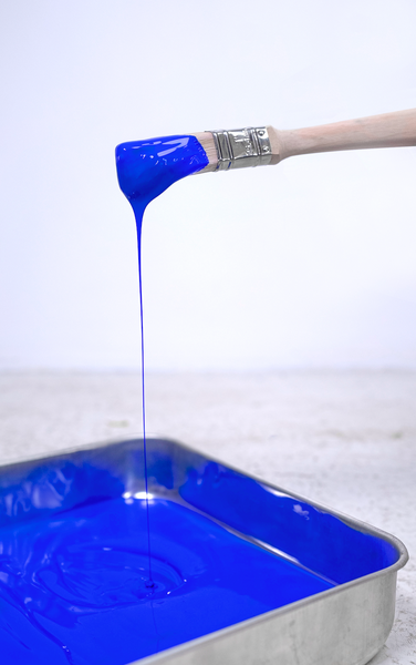 YesColours Electric Blue paint dripping from a paint brush and into a metal paint tray filled with Electric Blue paint