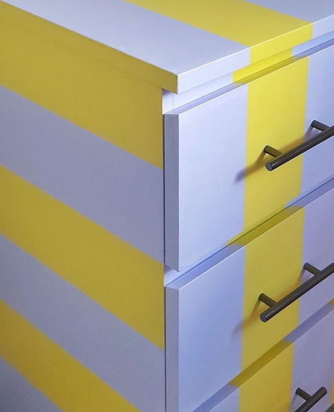 close-up photo of an upcycled chest of drawers, painted in YesColours Fresh Lilac and Calming Yellow paint stripes