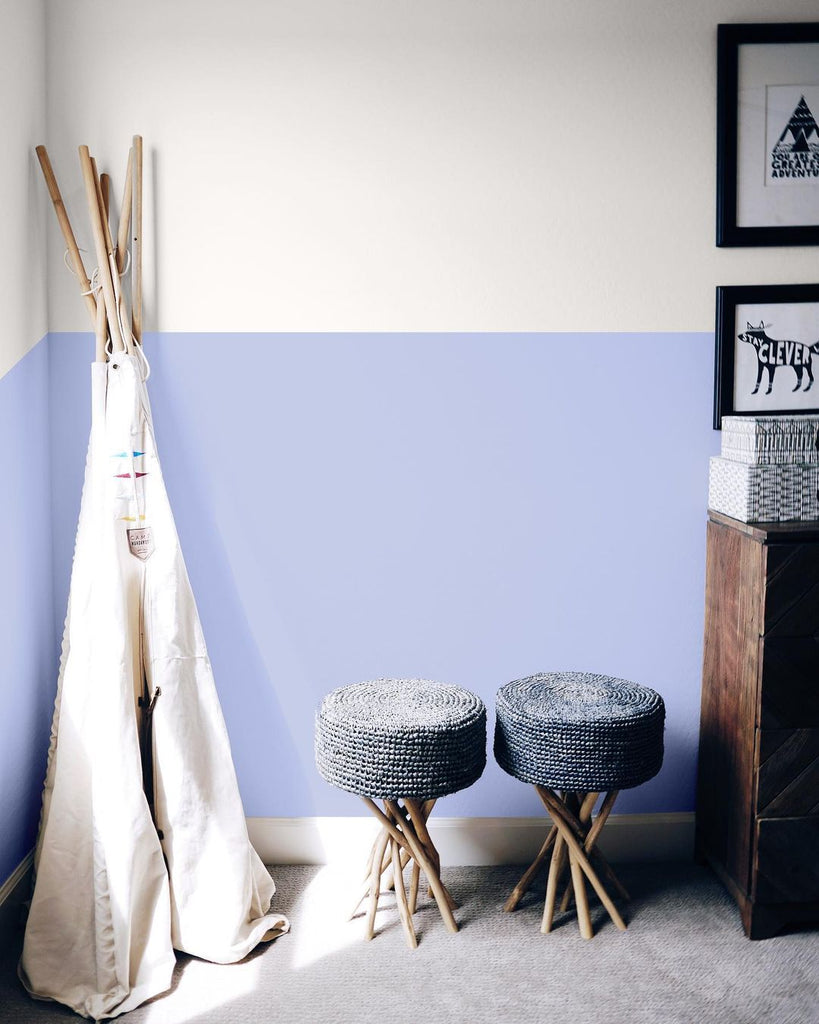 Nursery room with children's tent and two stools, photographed in front of a split-tone wall in neutral and dirty lilac paint colours