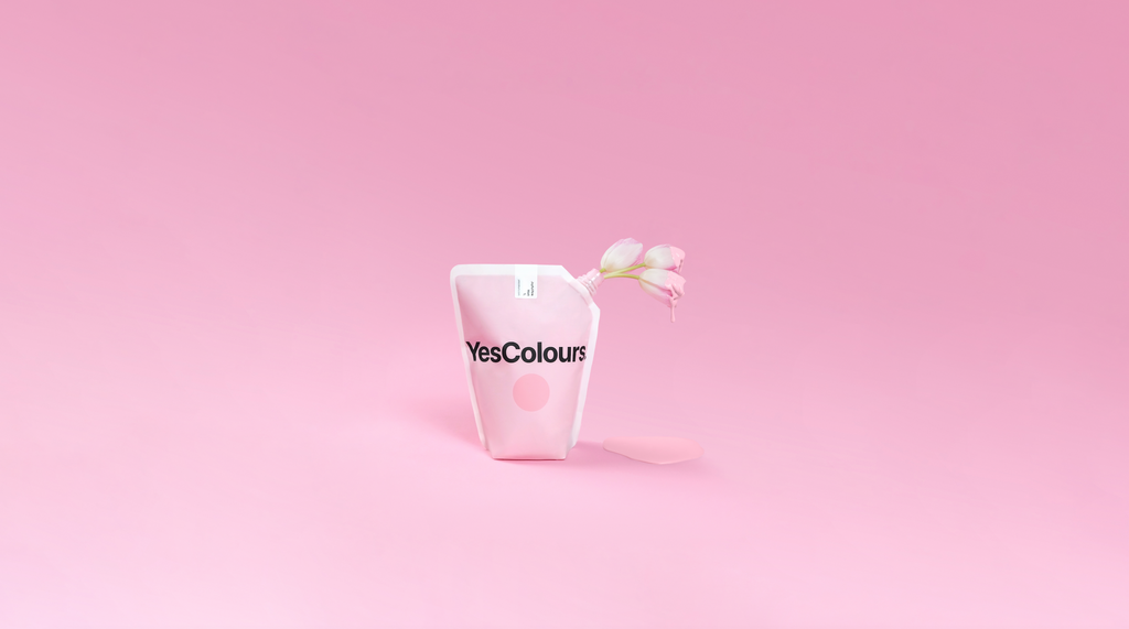 YesColours Joyful Pink paint colour paint pouch with tulips covered in paint inside photographed on a pastel bubblegum pink background