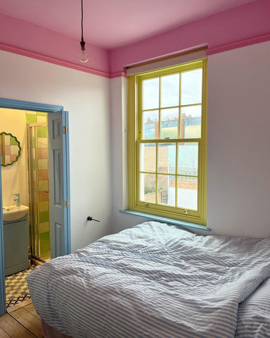 photo of a spare bedroom decorated in pink, yellow and blue