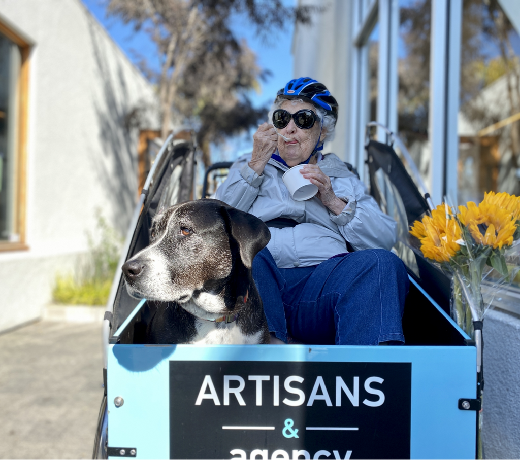 Senior woman with Christiania cargo bike with a dog