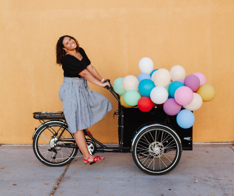 woman on a cargo bike with balloons