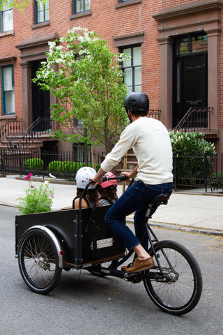 Dad riding daughters around in the front of their Christiania cargo bike