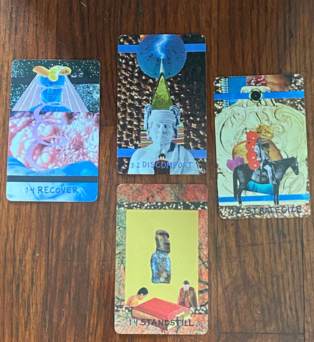 4 Fourfold Oracle Cards are laid on a mahogany wood floor in a cross formation