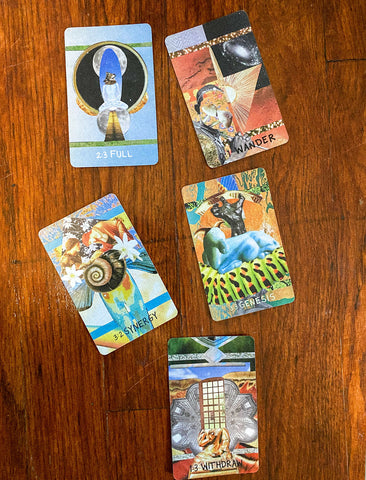 Five Fourfold Oracle cards on mahogany wood floors