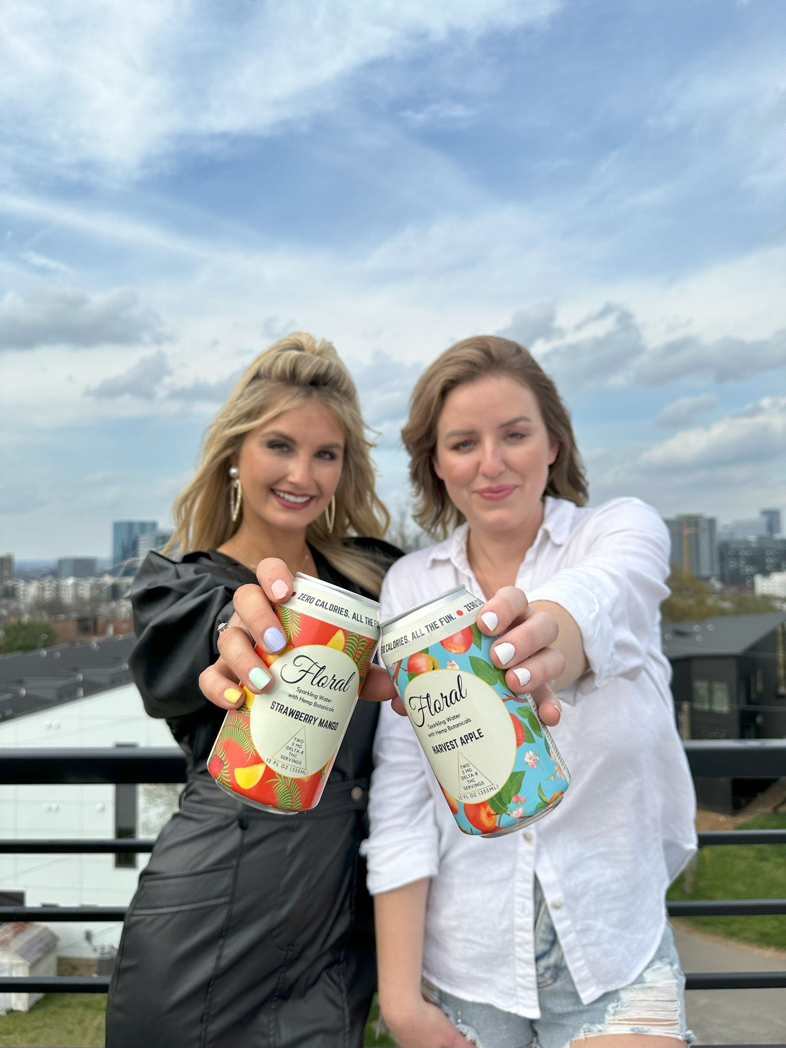 Two woman holding cans of Floral Beverages THC-infused seltzers
