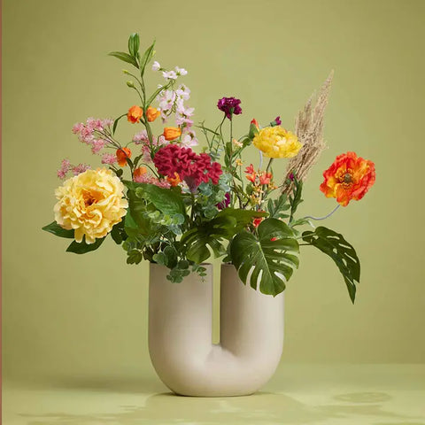 Moderne Vase mit unterschiedlichen Kunstblumen