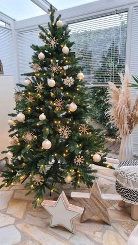 Künstliche Weihnachtsbäume wie echt gold weiß dekoriert in einem Wintergrarten