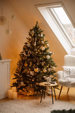 Tannenbaum künstlich an einem Fenster mit Goldenem und weißem Schmuck