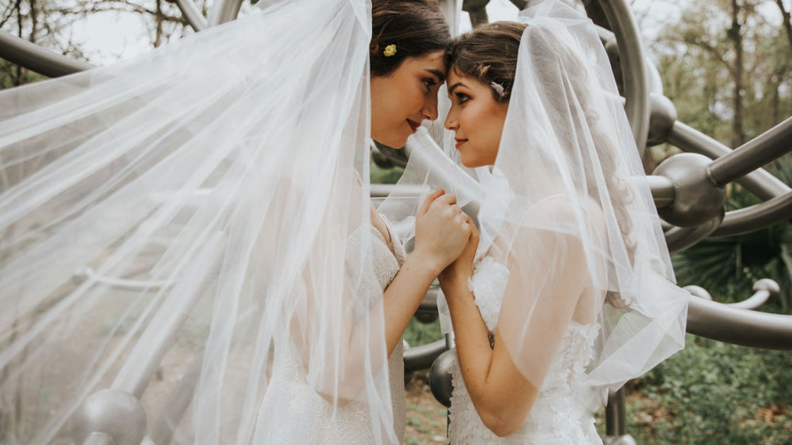 Two brides are better than 1 brides holding hands and gazing into each other's eyes on wedding day holding hands