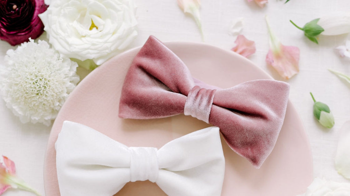 Two brides are better than 1 two velvet bow ties in white and pink colors flay lay with pink and white flowers