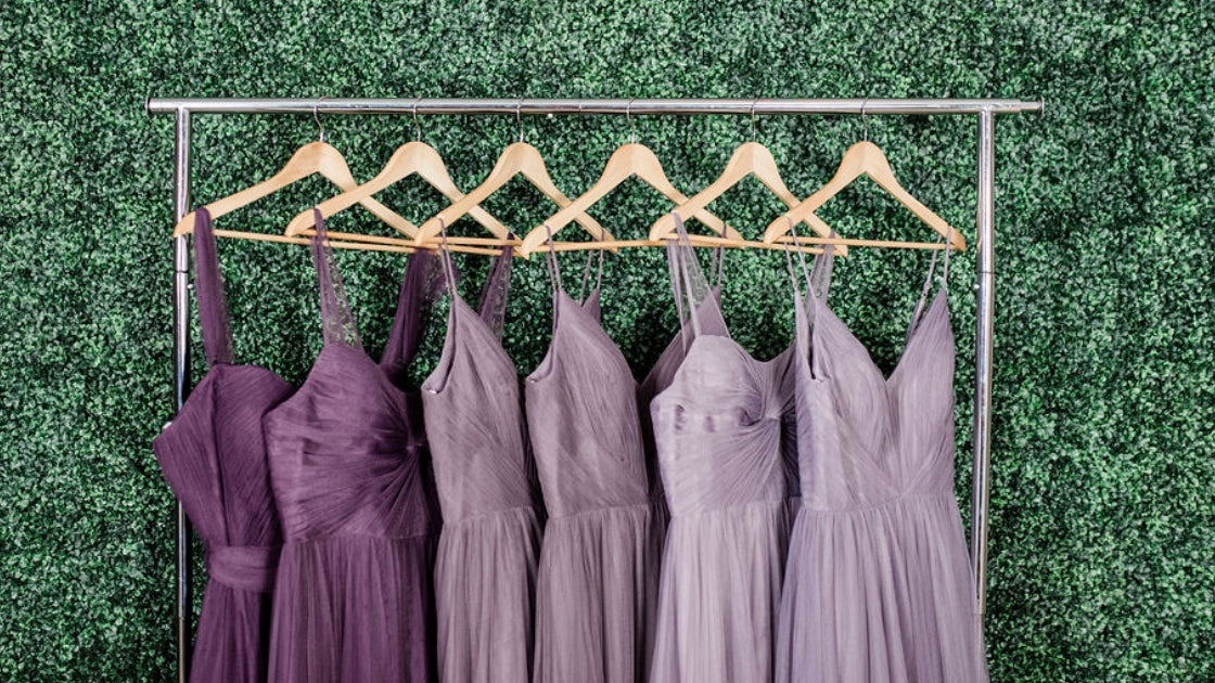 Rack shot tulle bridesmaid dresses purple gowns dark purple wisteria lilac greenery plan wall