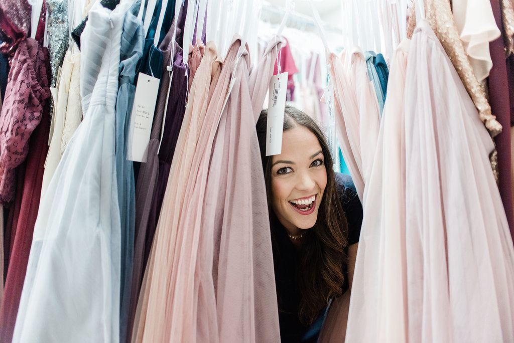 Michelle founder of revelry pokes her head out of different colors tulle skirts being silly