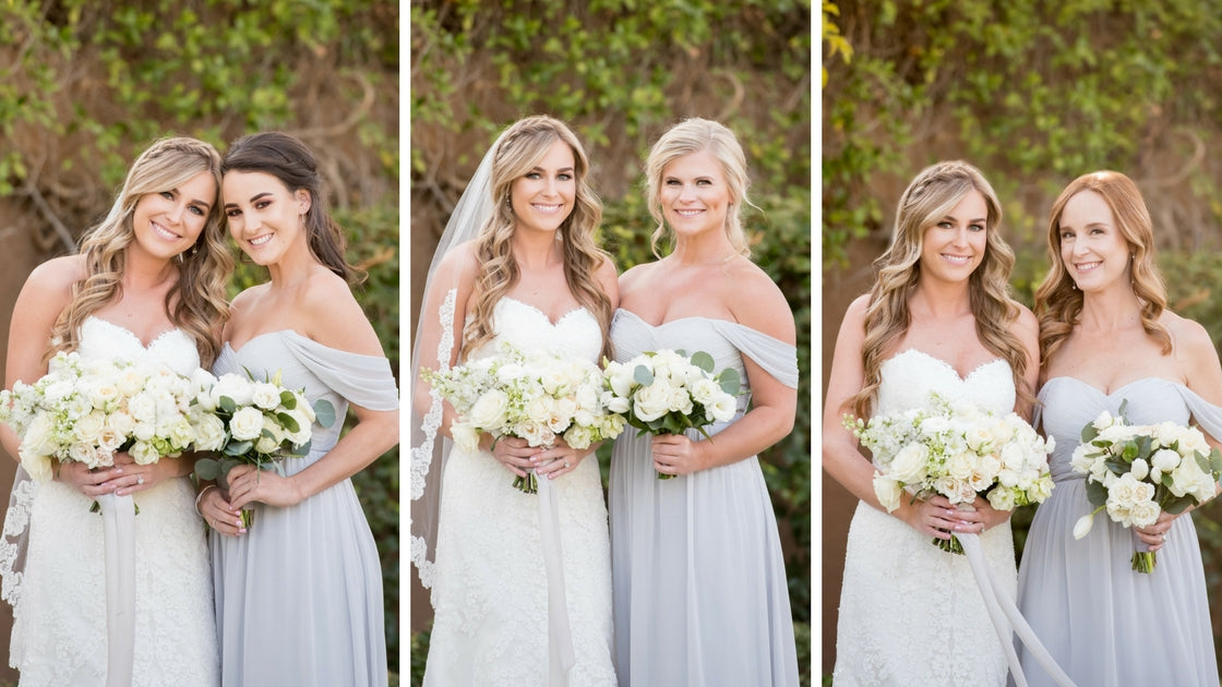 bride poses with each bridesmaids holding beautiful white blooms. 