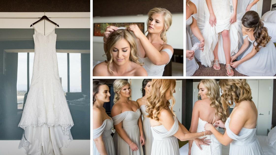 Bridesmaids help bride get ready while wearing Dove Grey Chiffon Bridesmaid Dresses from Revelry.