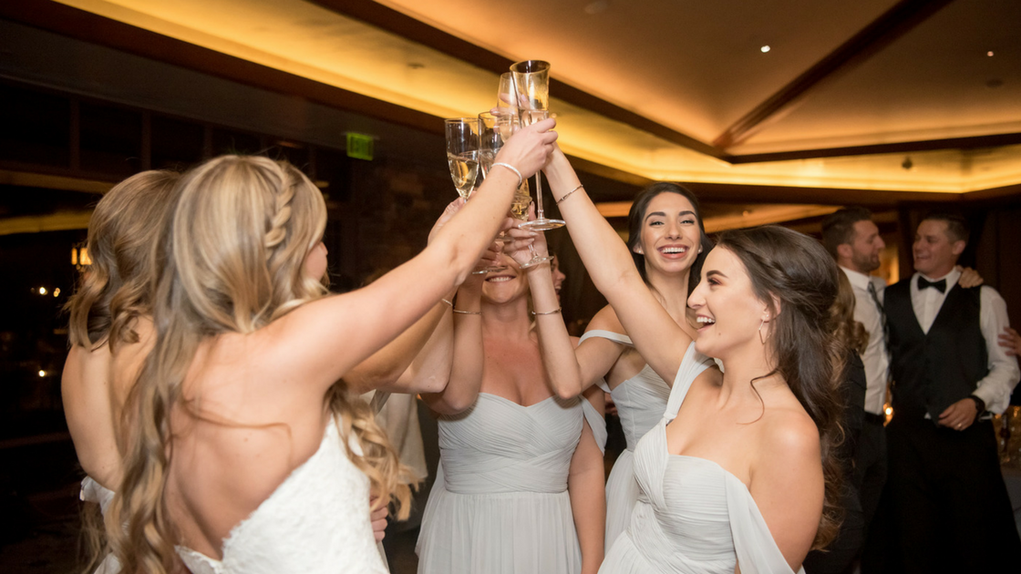 bridesmaids toast on the dance floor together. 