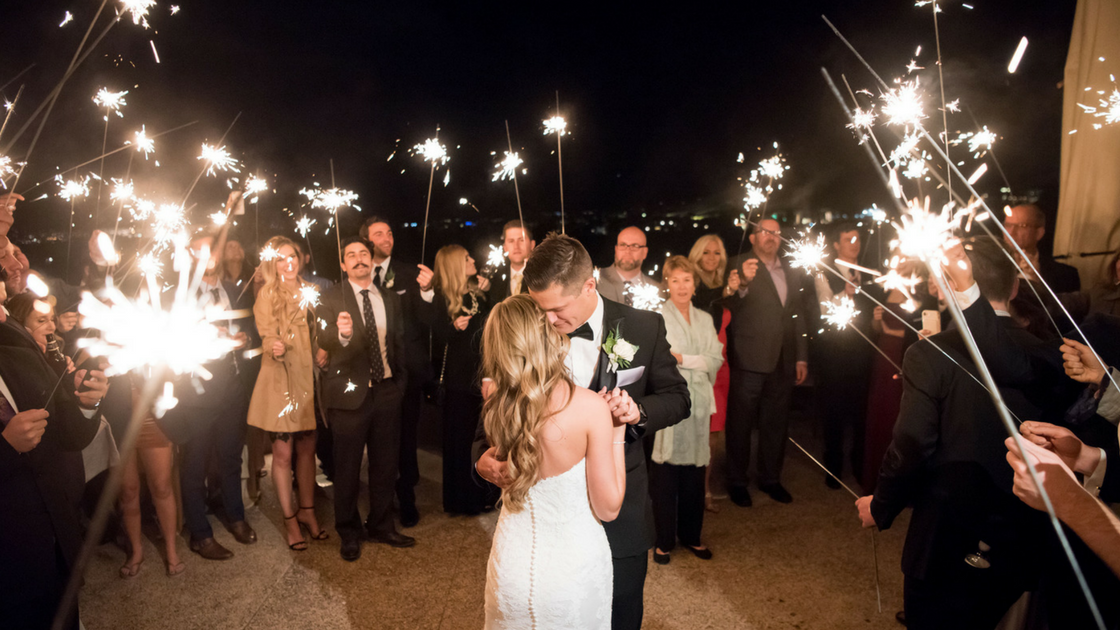 bride and groom kiss under twinkling sparklers as they make their exit. 