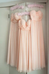Three peach dresses hanging up together