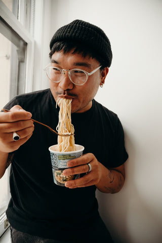 Man eating Mike's Mighty Good noodles