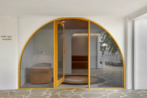 Front view of the spa, prominently featuring a custom yellow arch door, creating an inviting and distinctive entrance that embodies the spa's vibrant and unique design ethos.