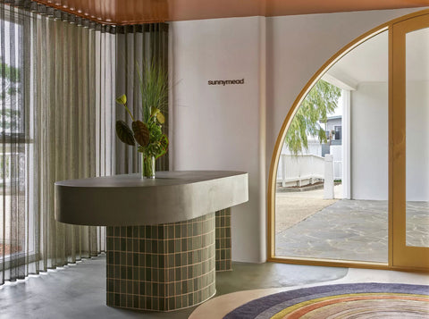 Curved reception desk at Indie Spa, adorned with vibrant green tiles, creating a welcoming focal point in the spa's entrance area.