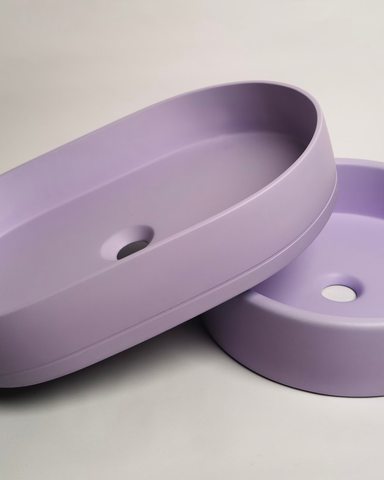Side-by-side arrangement of a lilac pill-shaped basin and a lilac bowl-shaped basin, showcasing their elegant lilac hues and distinct shapes for modern interior design inspiration.