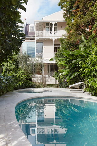 The facade of the terrace house is painted in a soft, light pink hue, creating a charming and inviting exterior. White railings accentuate the elegant design, providing a striking contrast and enhancing the overall aesthetics of the building.