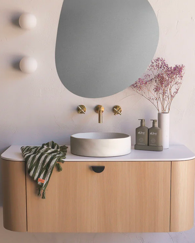 Slip basin in Morning Mist by Nood Co on a vanity setting with an organic mirror and gold tapware.