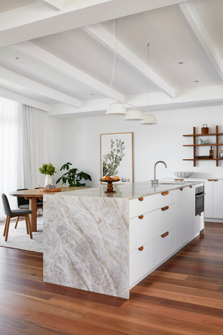 Mandurah Foreshore kitchen offering a harmonious mix of natural stone surfaces, light wood, and white accents.