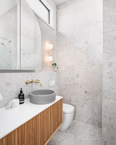 Photo of a modern ensuite designed by Georgia Neale for M.J. Harris Group, featuring a Nood Co Bowl Basin in Sky Grey, captured by photographer J-HAZ. The image showcases a sleek, contemporary bathroom with minimalist styling, emphasizing the basin's unique color and shape against a backdrop of elegant, neutral tones.
