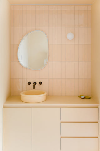 Front view of the bathroom, showcasing an organically shaped mirror and brass tapware by Sussex Taps, harmonizing with the Sunny Yellow theme for a refined and cohesive look.