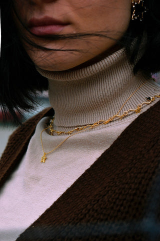 Stylish combination of a turtleneck sweater and layered necklaces on a woman