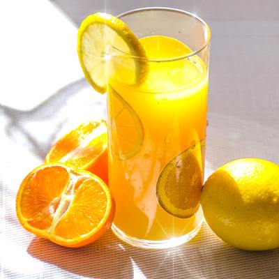 Glass of orange juice with oranges surrounding glass