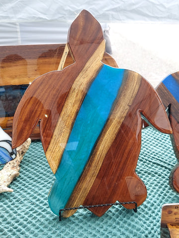 Dark wood with lighter wood stripes and blue epoxy resin in the shape of a turtle.