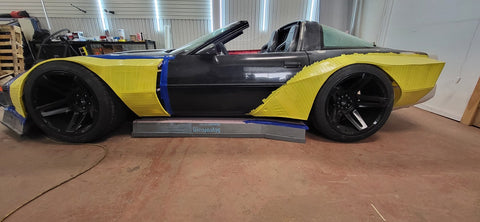 Side view of corvette with yellow tape over side panels ready for fiberglass and resin.