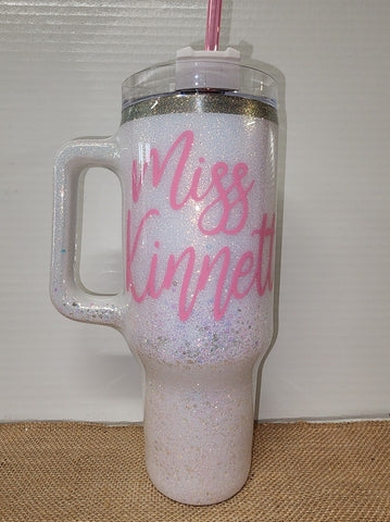 Water tumbler with white background and pink name with epoxy resin seal over outside.