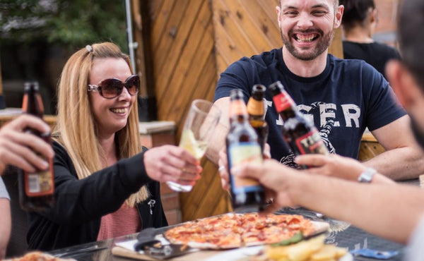 Friends enjoying pizza and beer