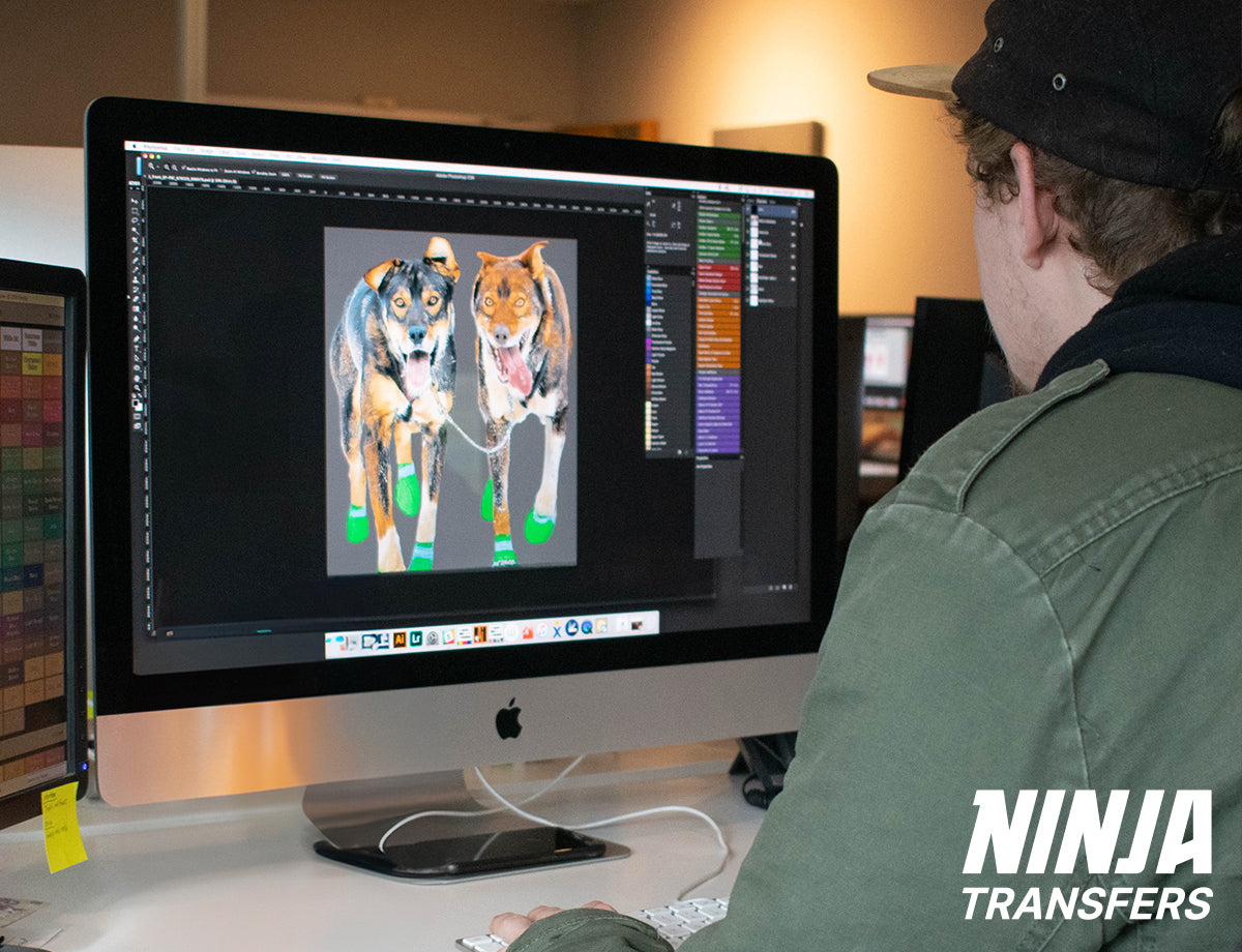 Over-the-shoulder view of a designer working on t-shirt graphics on their computer