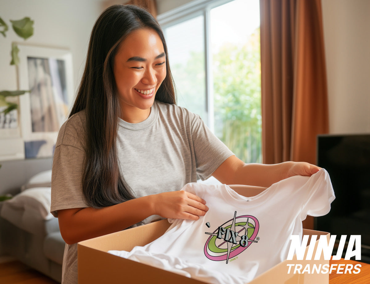 Customer unboxing their order and smiling as they hold up a printed t-shirt