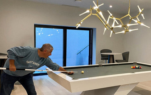 man playing on a pool table in hamptons home