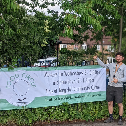 Joe Fennerty standing next to the Food Circle York banner on railings at Tang Hall Community Centre