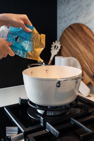 Pouring Arborio rice into the Cosmo Casserole.